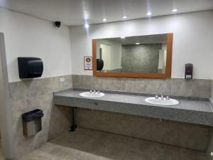 a bathroom with two sinks and a mirror at Rancho Aparte Hostel in El Chalten