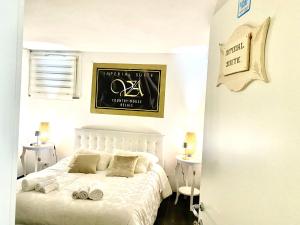 um quarto com uma cama branca e uma placa na parede em VILLA di L ABBIU FARMHOUSE , ROOMS DESIGN & RELAX em Sorso