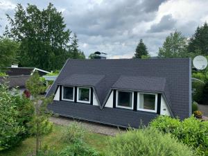 una casa con un techo negro encima en Eifel Residence, en Gerolstein