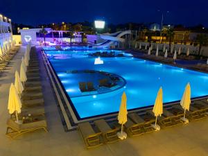 a large swimming pool at night with chairs and umbrellas at Sunthalia Hotels & Resorts Ultra All Inclusive Adults Only Party Hotel in Side