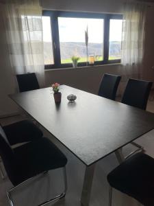 a dining room table with chairs and a large window at Ferienwohnung Pfalzblick in Bacharach