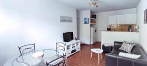 Una sala de estar con una mesa de cristal y un sofá. en VK Lake, en Aureilhan