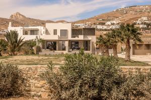 une maison dans le désert avec des montagnes en arrière-plan dans l'établissement Yenesis Seaside Retreat - Adults only, à Tinos