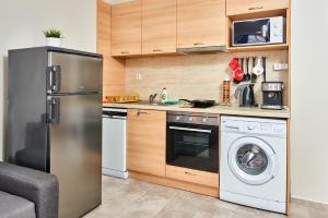a kitchen with a stainless steel refrigerator and a dishwasher at Студио Калина in Pomorie