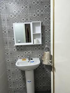 y baño con lavabo y espejo. en appart casa voyageurs belvédère, en Casablanca