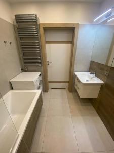 łazienka z umywalką, wanną i toaletą w obiekcie Apartament Atrium w mieście Gdynia