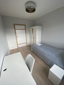 een slaapkamer met een bed, een bureau en een tafel bij Apartament Atrium in Gdynia