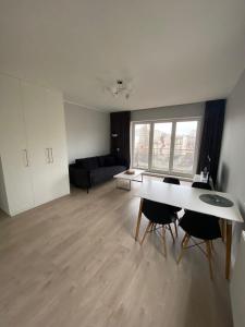 een woonkamer met een tafel en stoelen en een bank bij Apartament Atrium in Gdynia