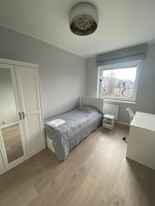 een kleine slaapkamer met een bed en een raam bij Apartament Atrium in Gdynia
