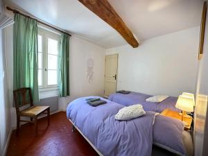 sypialnia z 2 łóżkami, krzesłem i oknem w obiekcie Maison Elsud LA GARDE-FREINET centre 3 Chambres Terrasse Parking w mieście La Garde-Freinet