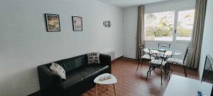 Una sala de estar con un sofá negro y una mesa. en VK Lake, en Aureilhan