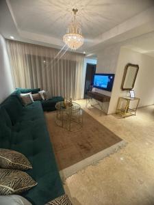 un soggiorno con divano blu e TV di Appartement luxe avec piscine Marrakech a Marrakech