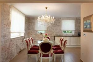 a dining room with a table and chairs and a chandelier at Villa Ema in Tar