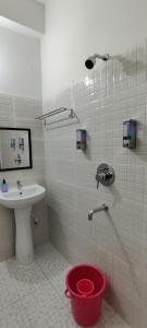 uma casa de banho com um chuveiro, um lavatório e um balde em USC Home Stay-307 em Guwahati