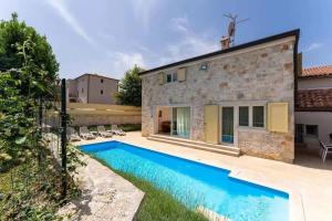 a villa with a swimming pool in front of a house at Villa Ema in Tar