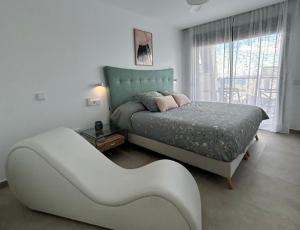 a white bedroom with a bed and a window at Iconic Alluba Alicante luxury bay in Gran Alacant