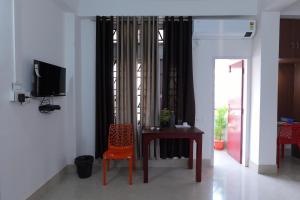 um quarto com uma mesa, uma cadeira e uma televisão em USC Home Stay-307 em Guwahati