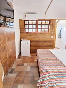 聖塞巴斯蒂安的住宿－Suítes Praia Barequeçaba，一间卧室配有一张床和一个小冰箱