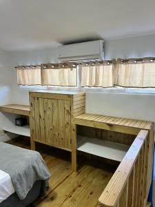 ein Schlafzimmer mit einem Bett, Holzregalen und einem Bett in der Unterkunft HILLMON'S HOTEL BAR LOUNGE in Sosúa