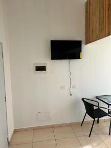 eine weiße Wand mit einem TV an der Wand in der Unterkunft HILLMON'S HOTEL BAR LOUNGE in Sosúa