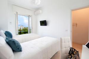 un soggiorno bianco con divano bianco e finestra di AMORE RENTALS - Villa Tittina a Sorrento