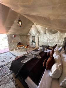 a bedroom with a large bed in a tent at Sahara Desert Camp in Adrouine