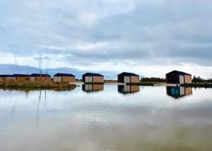 a group of houses on a body of water at Lakeside Fishing Retreats in Old Leake
