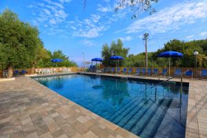 a large swimming pool with blue umbrellas and chairs at AMORE RENTALS - Villa Tittina in Sorrento