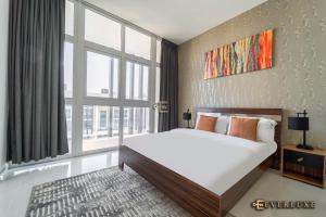 a bedroom with a bed and a large window at Everluxe Smart 2 Bedroom Villa In Akoya in Dubai