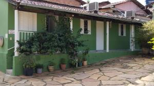 a green house with potted plants in front of it at Pouso da Lapa in Pirenópolis