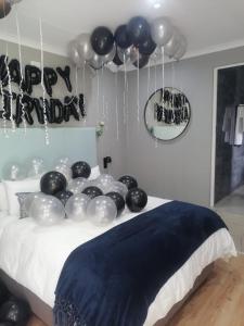 a bed with a bunch of balloons on it at Hillsview, Roodepoort in Roodepoort