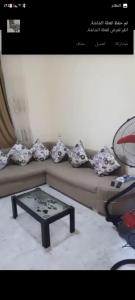 a living room with a couch with a table at شقة in Cairo