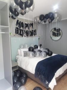 a room with a bed with black and silver balloons at Hillsview, Roodepoort in Roodepoort