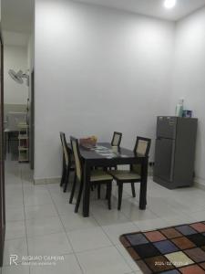 a dining room table with chairs and a refrigerator at BONDA ROSNAH HOMESTAY in Arau