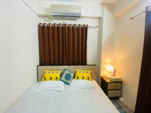 een slaapkamer met een bed met gele en blauwe kussens bij Entire place- Ac 2BHK Apartment Basundhara R/A in Dhaka