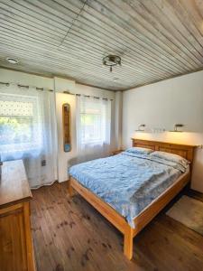 sypialnia z łóżkiem z niebieską kołdrą w obiekcie Domek gościnny Stara Stolarnia w mieście Kleosin
