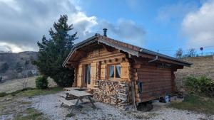 una cabaña de madera con un banco delante en Le Petit Chalet du haut du Salève 