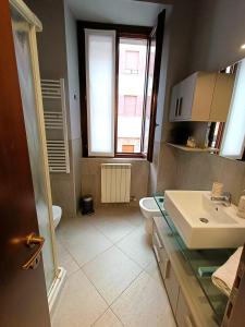 bagno con lavandino, servizi igienici e finestra di La Suite di Bianca - Monza a Monza