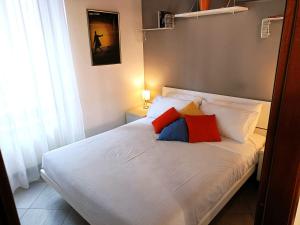 una camera da letto con un letto bianco con cuscini rossi e blu di La Suite di Bianca - Monza a Monza