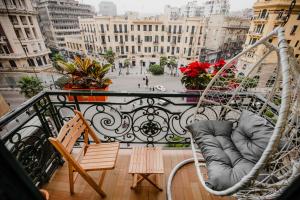 a porch with a swing and a chair on a balcony at The Square Boutique Hotel in Cairo