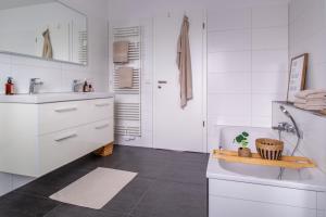 Baño blanco con lavabo y aseo en Penthouse-Ferienwohnung Wolfsburg, en Wolfsburg