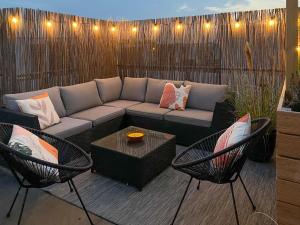 a patio with a couch and two chairs and a table at Penthouse-Ferienwohnung Wolfsburg in Wolfsburg
