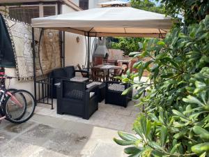 een patio met een parasol, stoelen en een tafel bij Casetta al mare MariaTeresa in Nocera Terinese