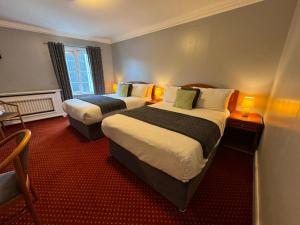 um quarto de hotel com duas camas e uma janela em The Killarney Grand em Killarney