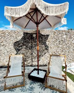 費特希耶的住宿－Villa Doğa 2，两把椅子放在墙上的伞下