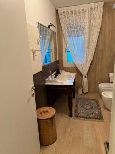 a bathroom with a sink and a toilet and a window at Casa D'Angelo in Vicenza