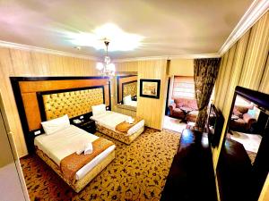 um quarto de hotel com duas camas e um sofá em Queens Suite Hotel em Beirute