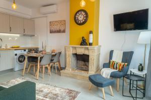 een woonkamer met een open haard en een tafel en stoelen bij Kostis Orange Resort in Volos