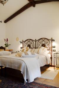 a bedroom with a large bed with white sheets at Domuseo in Quartucciu