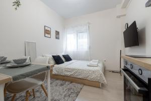 Sala de estar blanca con cama y mesa en Micro Studio 10 en Xanthi